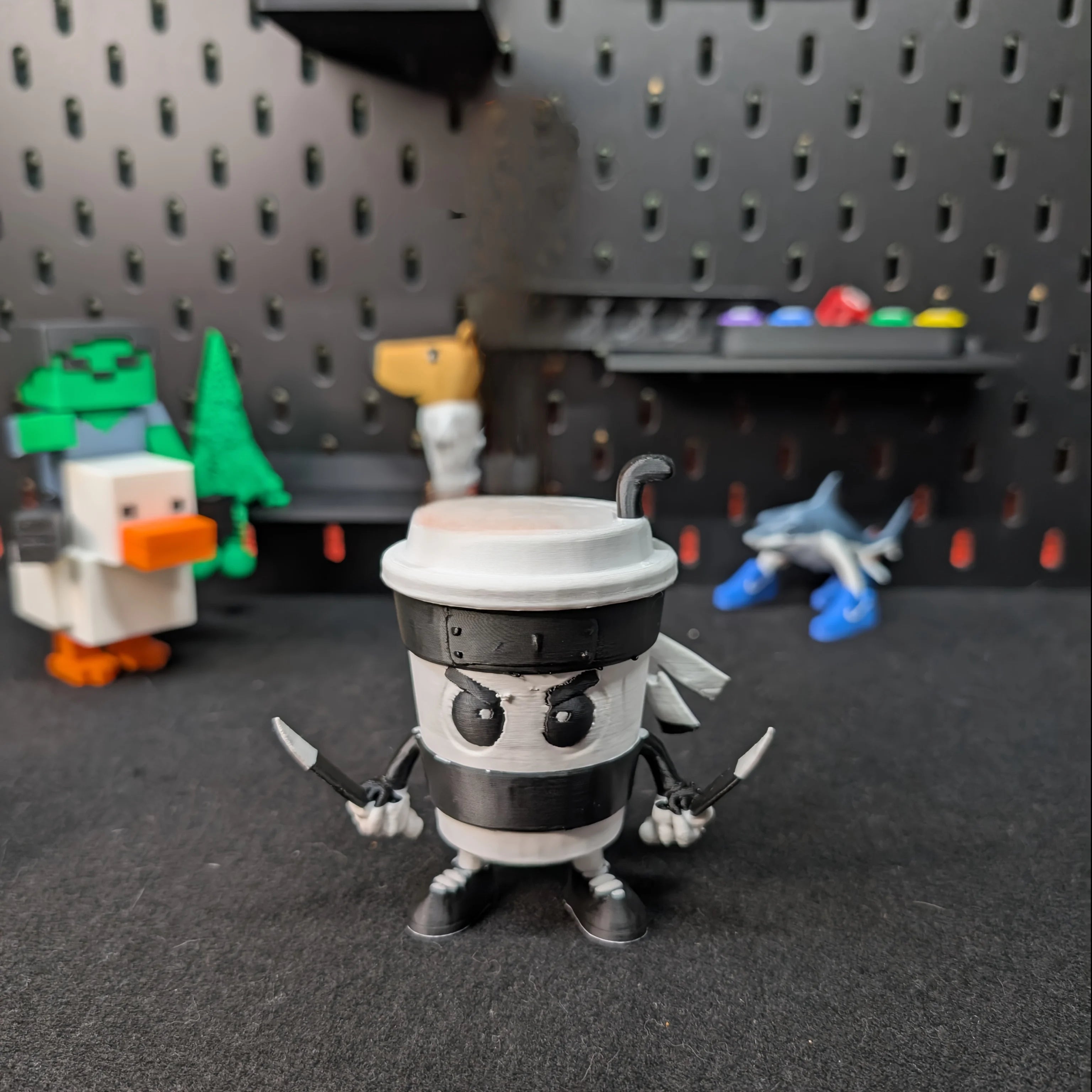 3D-printed Cappuccini Assassini Collector's Edition -  Animated character made from a coffee cup on a wooden surface with background kitchen items
